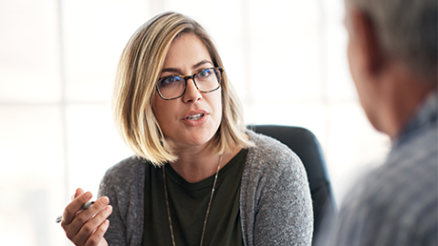 Woman having a serious discussion with a man who is out of focus
