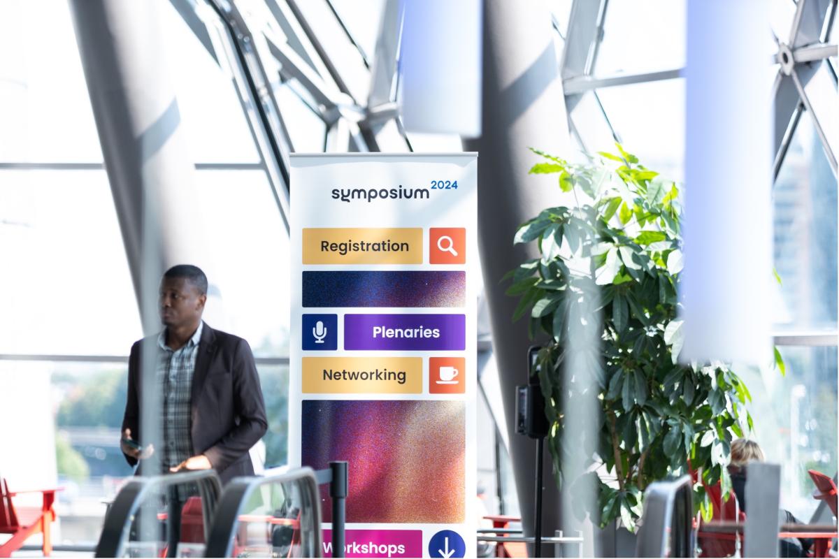 Symposium themed banner with icons and words registration plenaries and workshops in the Shaw Centre.