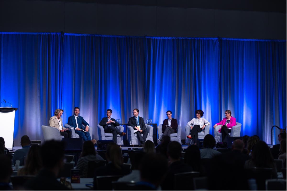 The panelists at the opening plenary sitting on stage.